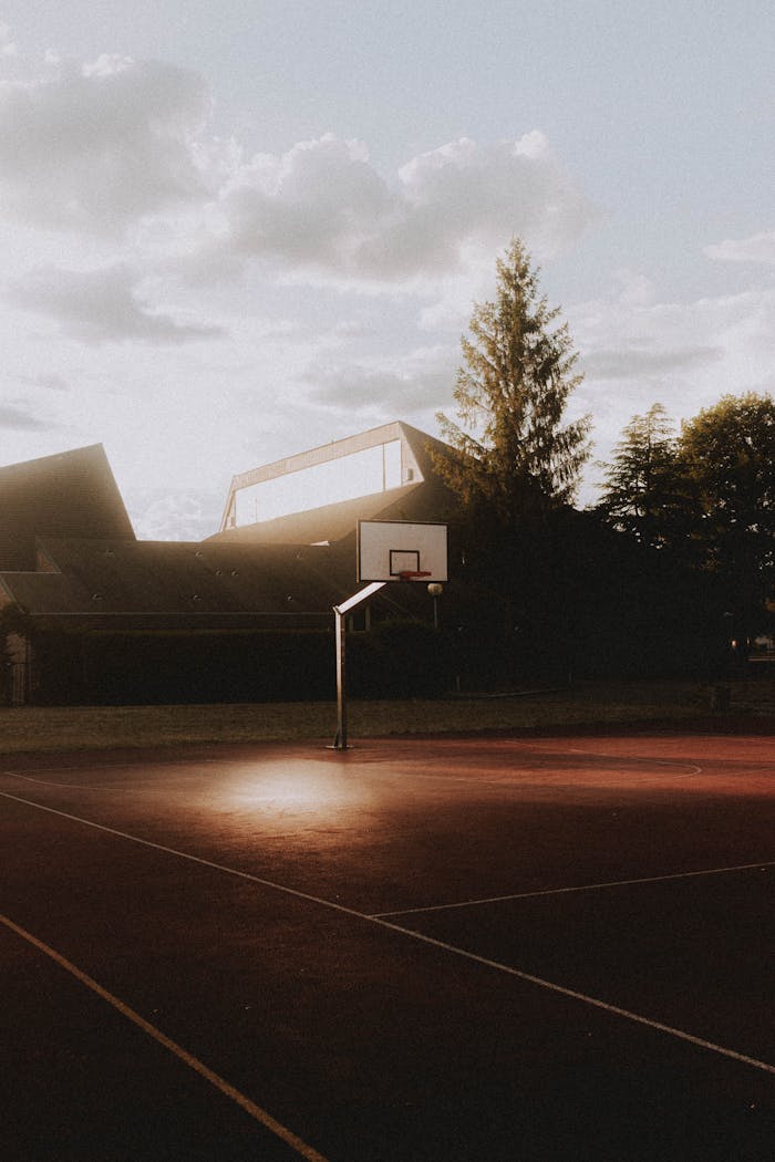Athletic field prepared for playing basketball and training near modern cottages in cloudy afternoon